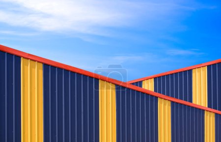 Deux murs en acier ondulé coloré alternativement des bâtiments d'entrepôt industriel sur fond de ciel bleu dans un style minimal, concept de conception d'architecture extérieure