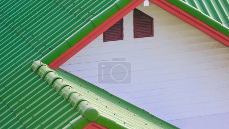 Foto de Azulejo de hormigón verde techo poligonal y combinación de madera blanca a dos aguas con ventana del ático de la casa vintage, ángulo alto y vista lateral perspectiva - Imagen libre de derechos