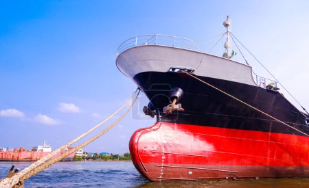 Oil tanker ship moored at shipyard during improvement and renovation work against blue sky background
