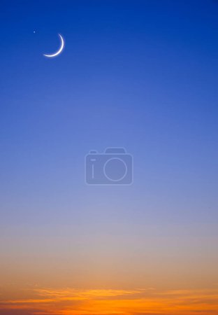 Crescent moon and star on twilight sky vertical background in early morning before sunrise with copy space for editing arabic text, Ramadan kareem, Eid al Adha, Eid al fitr, Mubarak, Islamic New Year