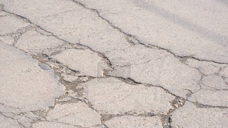 The old damaged concrete road background with broken and crack texture on surface