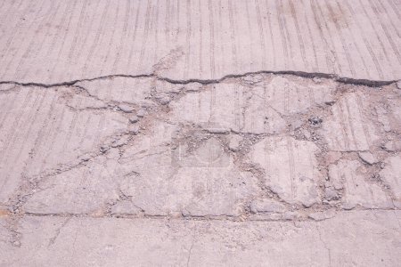 El viejo fondo dañado camino de hormigón con textura rota y grieta en la superficie
