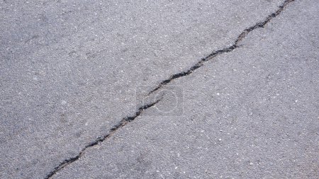 Two crack lines texture on surface of the old asphalt road background in diagonal view, top view with copy space