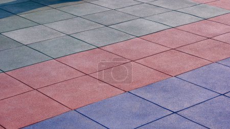 Mehrfarbiger EPDM-Gummiboden Textur Hintergrund des Spielplatzes im Freien mit Sonnenlicht auf der Oberfläche