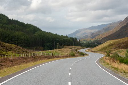 Téléchargez les photos : Une route ondulante au milieu des montagnes dans les Highlands, en Écosse - en image libre de droit
