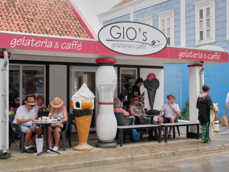Téléchargez les photos : Holidaymakers enjoying ice cream and coffee at Gio's Gelateria and caffe during warm weather in January in Kralendijk, Bonaire, Leeward Antilles. - en image libre de droit