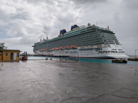 Téléchargez les photos : Vue de l'arrière du navire de croisière britannique P & O, Britannia amarré dans le port de Kralendijk, Bonaire, Antilles sous le vent par une journée nuageuse et humide des Caraïbes. Le Britannia est entré en service en 2015 et passe l'hiver dans les Caraïbes - en image libre de droit