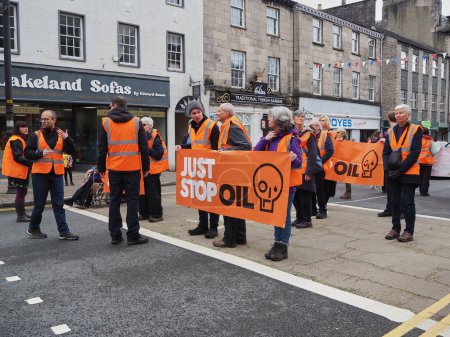 Téléchargez les photos : Les manifestants du groupe de pression Just Stop Oil marchent très lentement sur la route ralentissant la circulation pour protester contre les licences gouvernementales de forage pour le pétrole. - en image libre de droit