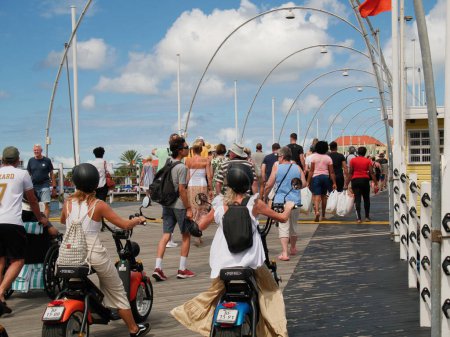 Téléchargez les photos : Personnes traversant le pont ponton articulé de la reine Emma à Willemstad, Curaçao, Antilles néerlandaises. Le pont de 167 m de long a été ouvert en 1888 et relie Punda à Otrbanda. - en image libre de droit