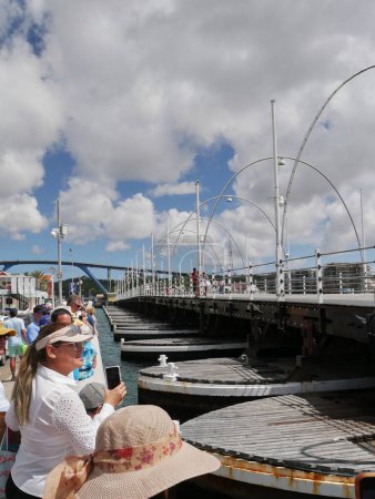 Téléchargez les photos : Le pont ponton Reine Emma à Willemstad, Curaçao, Antilles néerlandaises montré ouvert avec les pontons flottants et les touristes regardant. Le pont a été construit en 1888 pour relier les quartiers Punda et Otrobanda de la capitale. - en image libre de droit