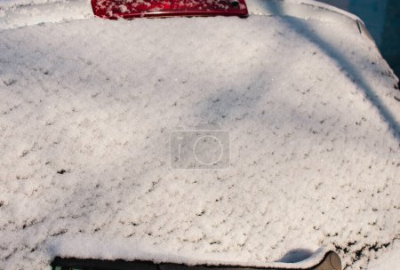 Téléchargez les photos : Une voiture grise dans la neige. Gros plan de la lunette arrière. - en image libre de droit
