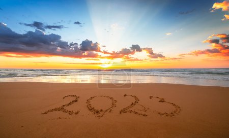 Beautiful sunset with 2023! Happy new year 2023 concept! Year 2023 written in the sand on the beach with the sea in the background