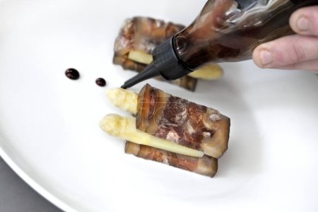 Téléchargez les photos : Bacon and asparagus on a plate with soy sauce - en image libre de droit