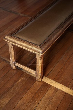 Photo for Wooden bench seat on a wooden floor - Royalty Free Image