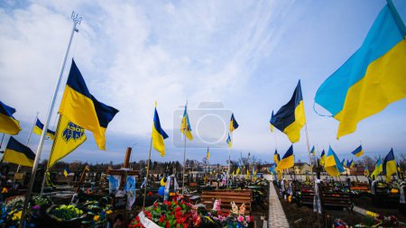 Téléchargez les photos : Tombeau d'un soldat ukrainien mort pendant la guerre au cimetière avec des drapeaux ukrainiens, 24.02.2023. Photo de haute qualité - en image libre de droit