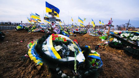 Téléchargez les photos : Tomb of a Ukrainian soldier who died in the war at the cemetery with Ukrainian flags, 24.02.2023. High quality photo - en image libre de droit