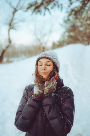 Téléchargez les photos : Jeune femme profitant du temps d'hiver dans la forêt de neige. Le froid. Vacances d'hiver, repos, concept de voyage. - en image libre de droit