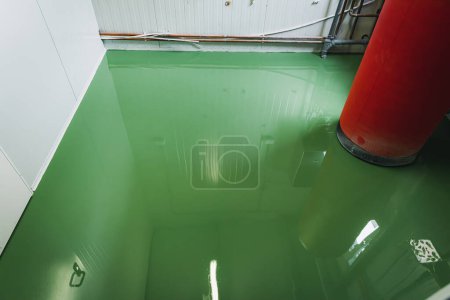 Téléchargez les photos : Epoxy and waxed green floor newly applied in the industrial hall - en image libre de droit