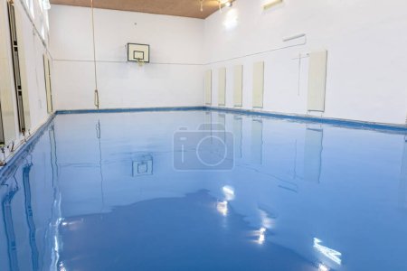 Auto nivelación piso epoxi azul en el gimnasio