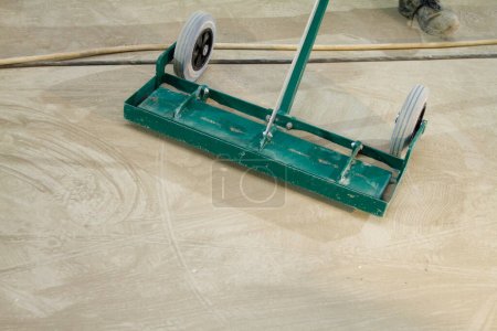 Téléchargez les photos : Le travailleur utilise habilement une brosse mécanique pour nettoyer et polir la surface du sol, en veillant à ce qu'elle reste en parfait état.. - en image libre de droit