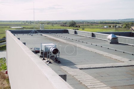 terrasse piétonne sur le toit de la salle industrielle est revêtue d'un matériau d'imperméabilisation pour protéger le bâtiment contre les dommages causés par l'humidité. 