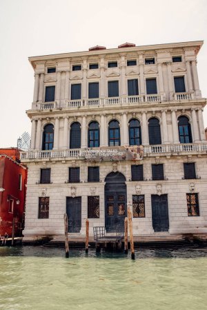 Foto de "Un hermoso edificio honra el Gran Canal de Venecia, exudando elegancia y encanto. Su magnificencia arquitectónica se destaca contra la serena vía navegable, mostrando la artesanía veneciana en su máxima expresión - Imagen libre de derechos