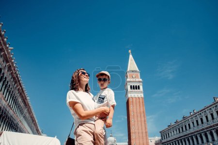 Téléchargez les photos : Une femme forte et belle se promène gracieusement à travers l'Italie, Venise, avec son précieux petit - en image libre de droit