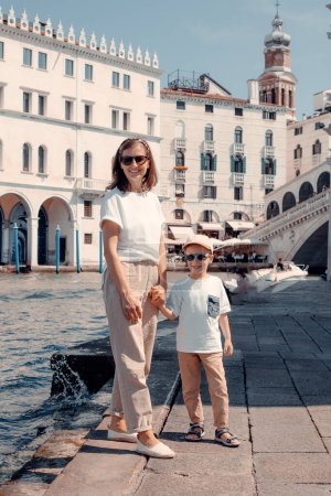 Téléchargez les photos : Une femme forte et belle se promène gracieusement à travers l'Italie, Venise, avec son précieux petit - en image libre de droit