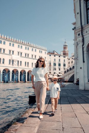 Téléchargez les photos : Une mère célibataire et son jeune fils se lancent dans une aventure magique, explorant les canaux pittoresques de Venise. Leur lien et leur joie rayonnent alors qu'ils naviguent dans les cours d'eau enchanteurs, créant de beaux souvenirs - en image libre de droit