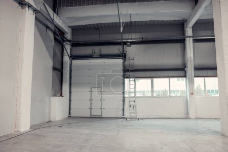 Téléchargez les photos : Volet roulant à l'intérieur d'un entrepôt. Peint et poli en blanc. - en image libre de droit