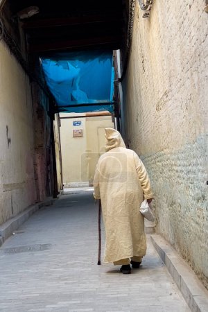 Foto de Vista trasera de un hombre musulmán con una Djellaba caminando en la Medina de Fez, Marruecos - Imagen libre de derechos