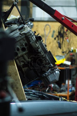 Foto de N motor viejo en reparación se está alimentando antes de la instalación en un coche gris viejo - Imagen libre de derechos