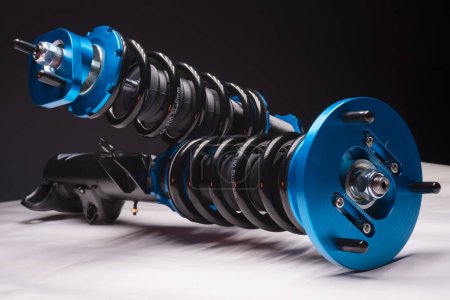 Auto-Fahrwerk-Tuning-Gewindefahrwerke Stoßdämpfer und Federn blau für ein Sport-Drift-Auto auf dunklem Hintergrund