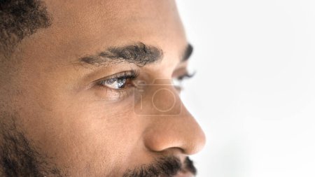 Photo for Handsome young African man looking away banner shot. Serious attractive Black guy upper face close up cropped portrait. Male model advertising eyes care, eyesight checkup, vision correction - Royalty Free Image