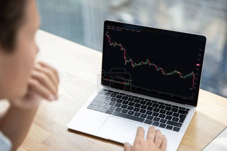 Stock market crash, cryptocurrency falling down, investment crisis, finance. Serious unknown businessman, trader sit at desk with laptop, close up screen show financial market chart graphic going down