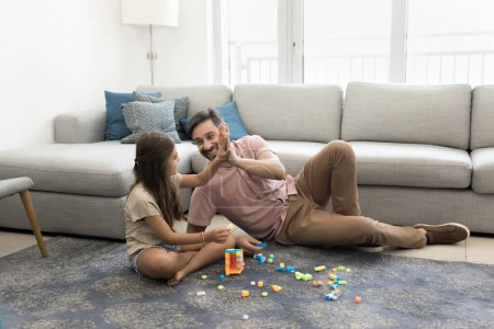 Photo for Cheerful proud dad and happy daughter kid giving high five over learning creative game, playing with toy building cubes, stacking tower, celebrating success, smiling, laughing, having fun - Royalty Free Image