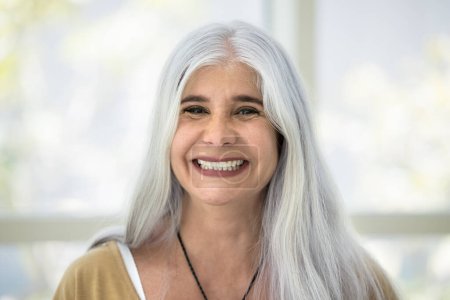 Photo for Happy naturally grey haired senior Latin woman head shot portrait. Cheerful elderly retired lady looking at camera with toothy smile, laughing, enjoying video call communication - Royalty Free Image