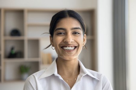 Photo for Cheerful petty Indian professional girl head shot video call portrait. Happy beautiful young woman keeping formal style, looking at camera with toothy smile, laughing - Royalty Free Image