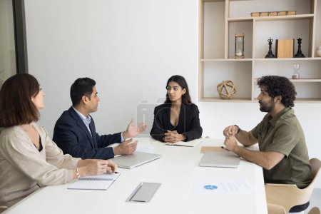 Photo for Multiethnic business partners discussing partnership, investment to startup, discussing agreement. Pretty young Indian businesswoman holding brainstorming meeting with employees - Royalty Free Image