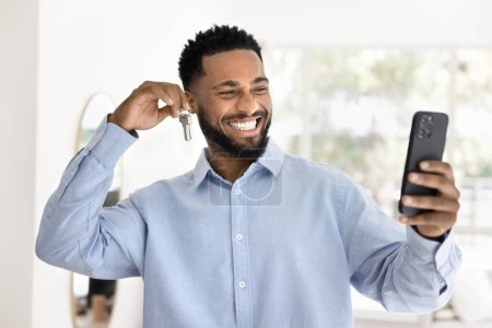 Glückliche neue afroamerikanische Makler halten Schlüssel, nehmen Selbstvideo für Blog n Smartphone, die Förderung von Immobilien-Service, Immobilienkauf und -verkauf im Internet