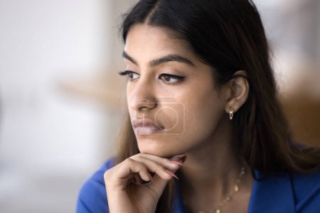 Photo for Sad pensive young Indian woman casual close up facial portrait. Concerned thoughtful 20s girl with nose stud touching chin, looking away, thinking on problems, bad news - Royalty Free Image