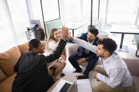 Photo for Cheerful diverse business colleagues celebrating successful startup. Office friends clapping hands in high five gesture, achieving success together, enjoying partnership, teamwork - Royalty Free Image