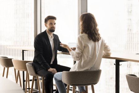 Photo for Focused couple of office friends talking in office lobby, discussing creative ideas for startup project. Young male and female young colleagues meeting, talking at large window - Royalty Free Image