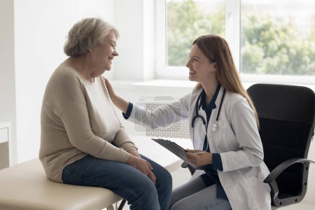 Photo for Happy optimistic physician woman giving help, assistance, support, medical advice to old 80s patient, touching shoulder of positive woman, telling optimistic prognosis of treatment - Royalty Free Image