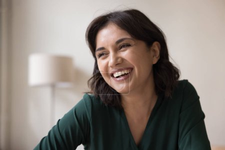 Portrait photo de la tête de la belle jeune femme arménienne souriant en regardant au loin profiter de bonnes nouvelles, ayant un large sourire franc dents, humeur optimiste et l'apparence attrayante. Beauté naturelle, émotions