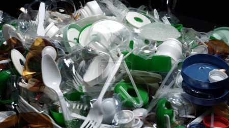 Plastikflaschenteile, Becher, Korken, Strohhalme, Wasser- und Shampooflaschen, Cremeverpackungen und andere einmalige Gebrauchsabfälle, die auf den Tisch geworfen werden. Umweltverschmutzung, Recycling, Müllproblem.