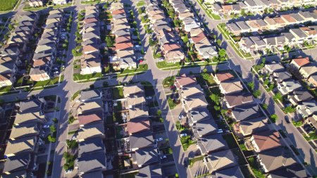 Téléchargez les photos : Vue aérienne de riches citoyens américains banlieue à l'heure d'or été. Vue immobilière établie des maisons résidentielles riches près de la verdure, des parcs et des arbres. - en image libre de droit