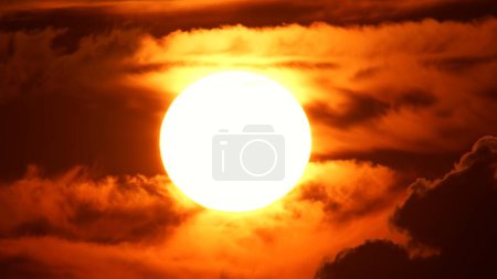 Téléchargez les photos : Coucher de soleil africain laps de temps avec grand disque solaire et nuages rétro-éclairés. Cinématique et épique chaud coucher de soleil d'été avec grand cercle de soleil rouge et orange. - en image libre de droit