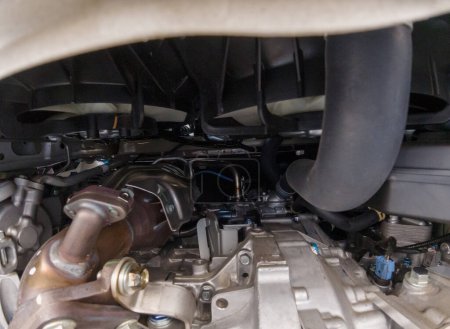 Foto de View of the car engine compartment by auto mechanic from below. Air radiator and cooling fans. Combustion engine and automatic transmission parts. Partial drivetrain in details. - Imagen libre de derechos