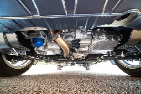 Foto de Car bottom view, part of catalytic converter in automobile exhaust system. Engine oil filter and pan. Transmission pan. Pre purchase inspection or pre delivery check up. Auto mechanic view. - Imagen libre de derechos